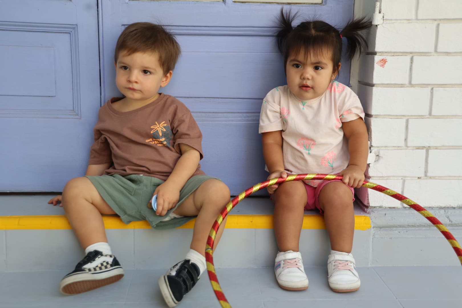 Dos niños jugando con un aro en el patio del Jardín Infantil Marco Polo, Las Condes