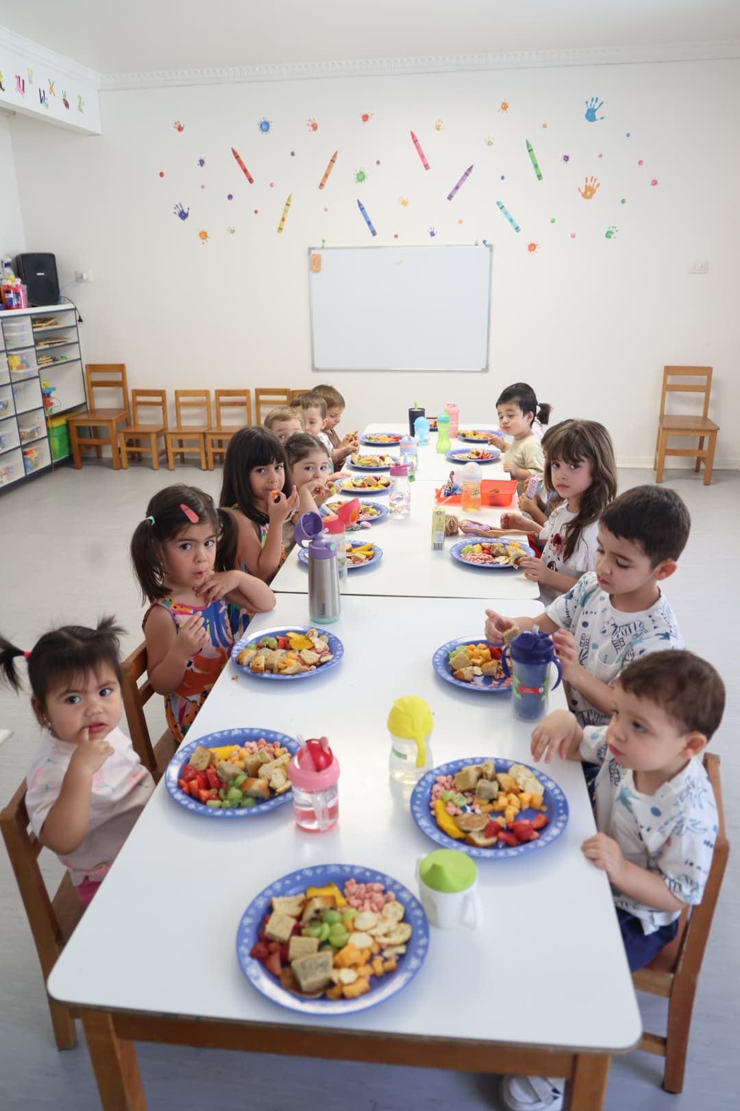 Niños en hora de colación en la sala del Jardín Infantil Marco Polo, Las Condes